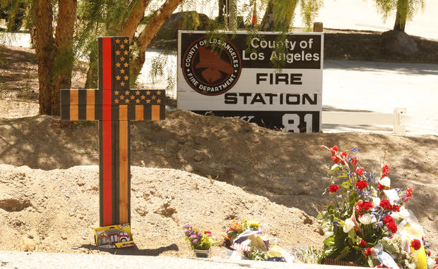 A memorial features a cross made of wood along with flowers is outside Los Angeles County Fire Dept. Station 81 at 8710 Sierra Hwy in Agua Dulce where  LA County Firefighter specialist Tory Carlon, 44, was killed in the shooting last Tuesday. The twenty-ye 