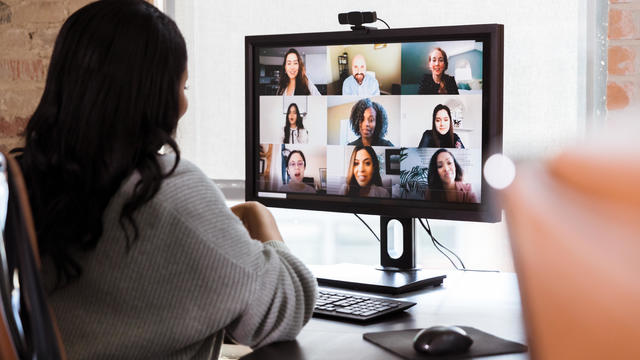 Businesswoman meets with colleagues during virtual staff meeting 