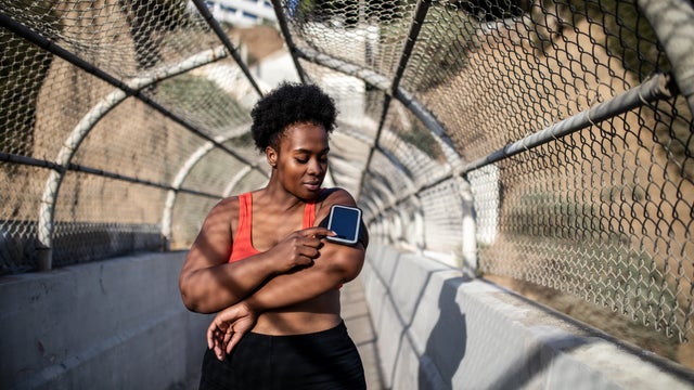 Healthy woman using phone on armband before exercising 