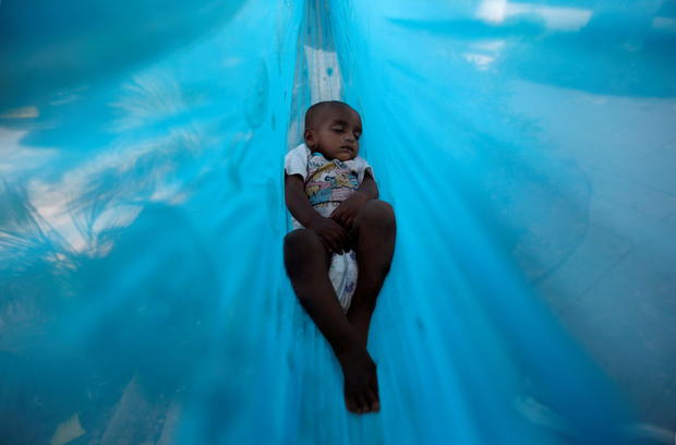 FILE PHOTO: Eleven-month-old Sakeena sleeps in a hammock on the promenade next to a lake in Mumbai 