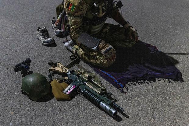 A member of the Afghan Special Forces prays on a highway before a combat mission against Taliban, in Kandahar province 