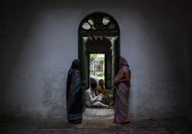 FILE PHOTO: Relatives of patrons listen to priests as they chant during evening prayers at the Mukti Bhavan in Varanasi 