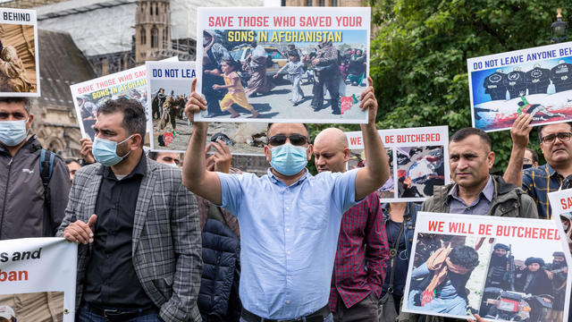 Protesters hold placards expressing their opinions during 