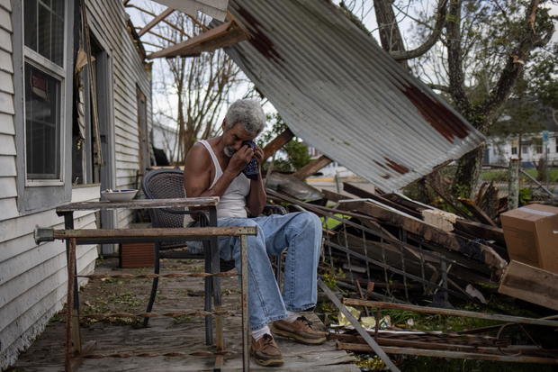 Man weeps on porch of home damaged by Hurricane Ida in Louisiana 