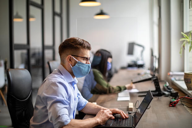 face mask Business people maintaining social distance while working in office 