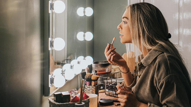 woman putting on makeup 