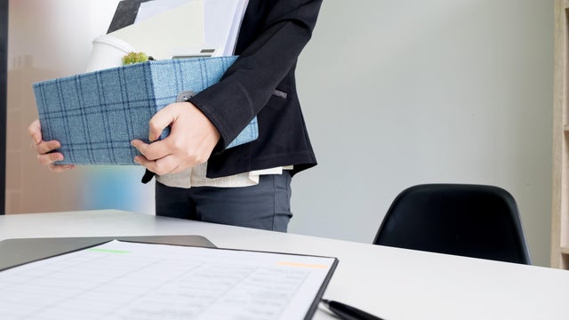 Midsection Of Woman Holding Box By Table At Office 