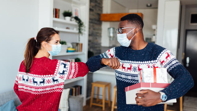 Young Caucasian woman welcoming her African American friend to her home 