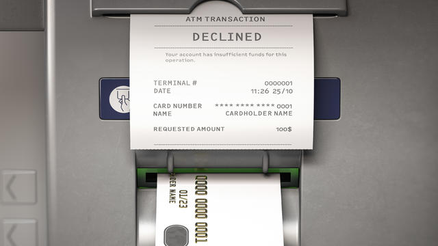 ATM machine and receipt with text declined for insufficient funds on account. 