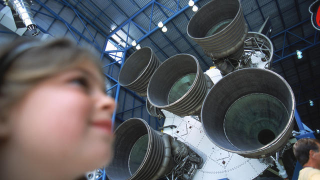 Girl next to Rocket Engines, Cape Canaveral, Kennedy Space Center, Florida, USA. 