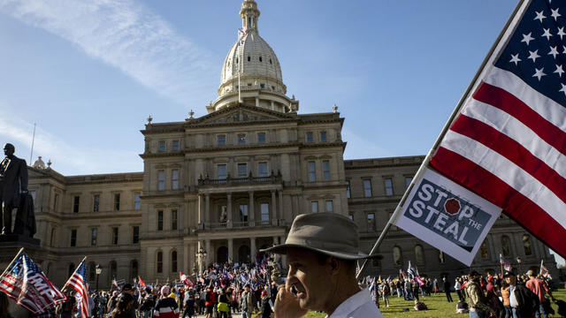 A man stands in front of the Michigan State Capitol Building 