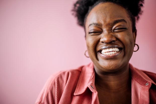 self love Young happy beautiful black woman posing in front of pink background 