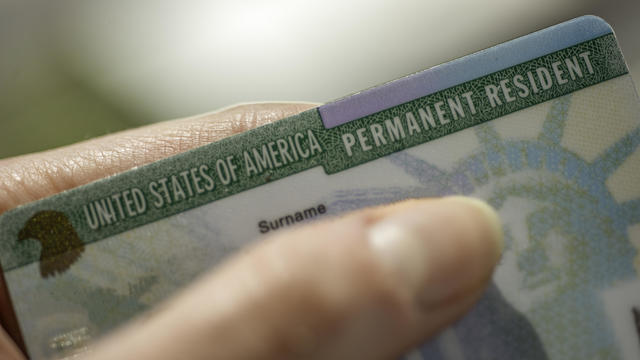 Close up view of Fragment of Permanent resident card (Green) card of USA on blurred background. 