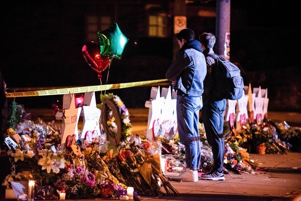 Mourner's pay respects in front of the memorial site.In the