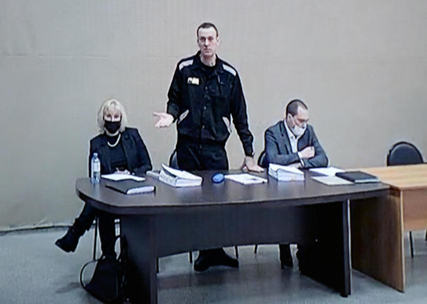 Russian opposition leader Alexey Navalny and lawyers Olga Mikhailova and Vadim Kobzev are seen on a screen via a video link during a court hearing at the IK-2 male correctional facility, in the town of Pokrov in Vladimir Region, Russia, February 15, 2022. 