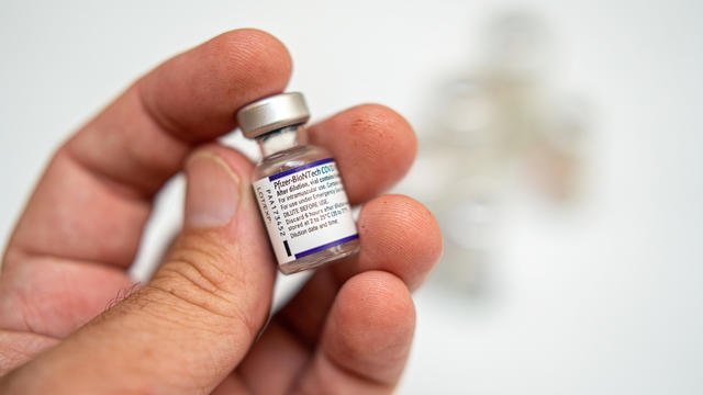 A health worker is holding a vial of Pfizer's Covid vaccine 