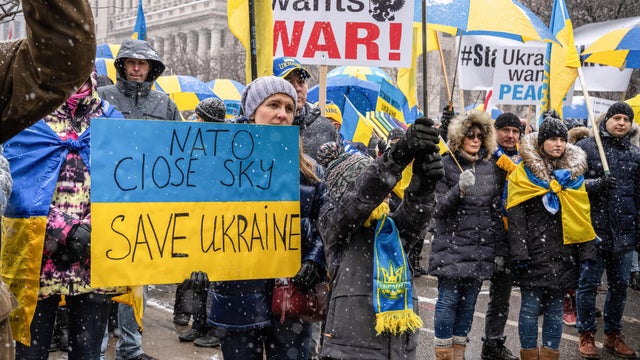 A protester holds a placard in colors of the Ukrainian flag 