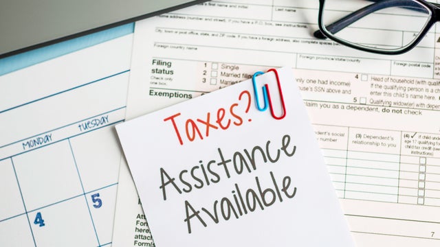 Person in plaid shirt holding dollars