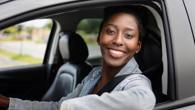 Portrait of young afro woman driving a car 