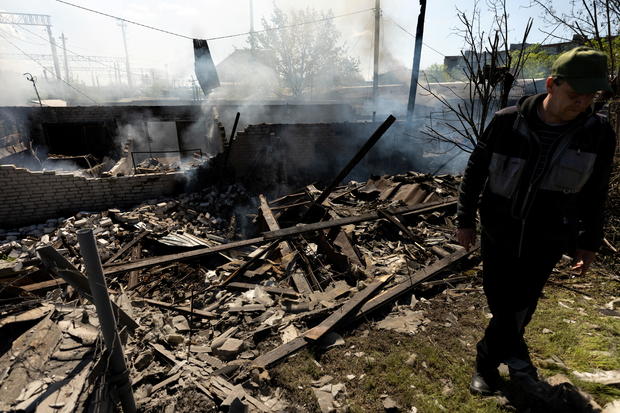 A man stands at the site of a destroyed garage following a military strike near the railway station in the frontline city of Lyman 