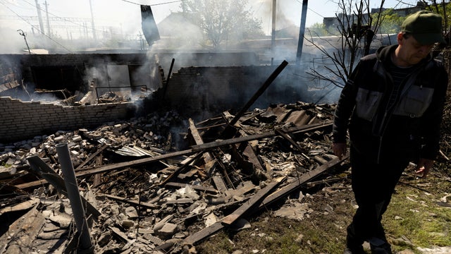 A man stands at the site of a destroyed garage following a military strike near the railway station in the frontline city of Lyman 
