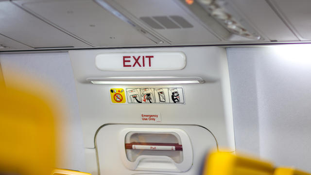 Close-Up Of Exit Sign In Airplane 