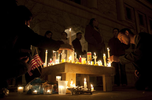 People pay their respects and light candles at a memorial for the victims of the shooting in Tucson 
