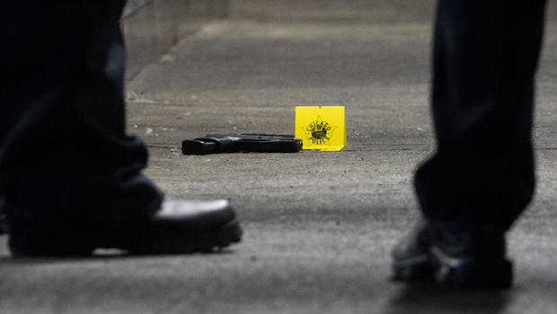 Gun sits on the ground at scene of a shooting 