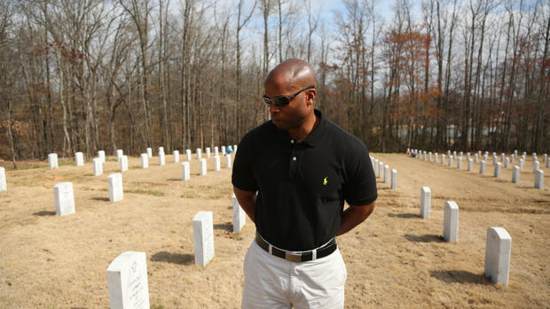Little Rock Police Lt. Troy Ellison looks at his father Eugene Ellison's gravestone 