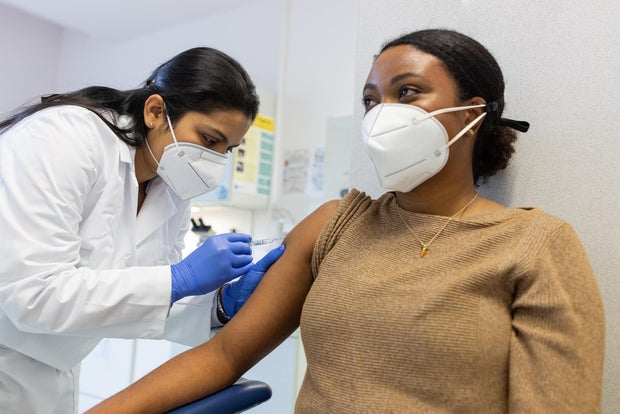 woman doctor vaccinating a young woman 