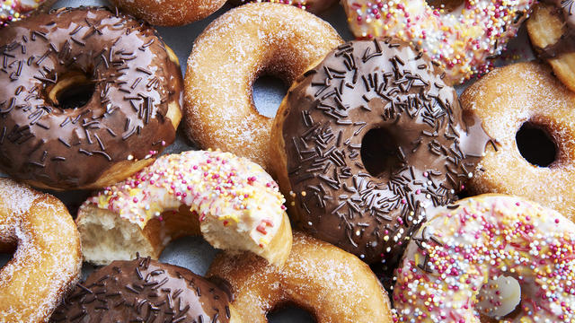 Ring doughnuts covered in icing and sprinkes 