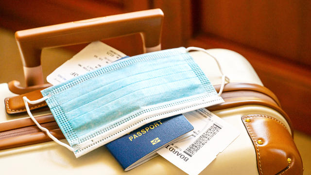Travel suitcase or luggage, passport, air ticket and facial mask during the pandemic of Coronavirus or Covid-19.. 