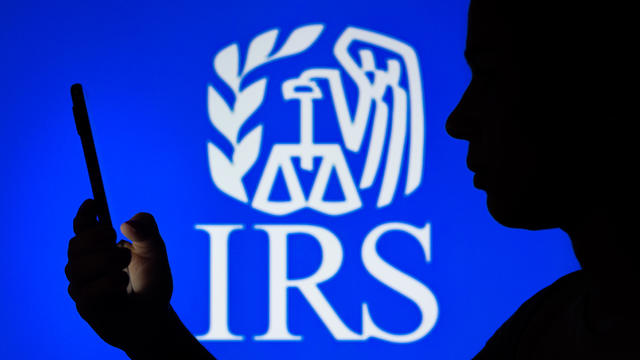 Silhouette against IRS logo on blue background 