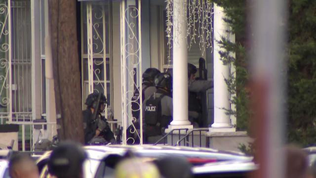 Heavily armed police officer approached the front door of a home after a police officer was shot in West New York​, New Jersey, on June 3, 2022. 