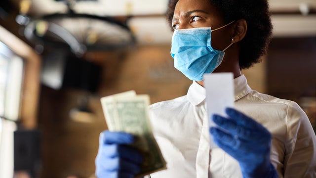 Black waitress feeling displeased about the tip from a customer. 