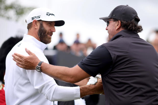 Dustin Johnson of 4 Aces GC greets Phil Mickelson of Hy Flyers GC during Day One of the LIV Golf Invitational - London at The Centurion Club on June 9, 2022, in St. Albans, England. 