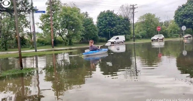 Wisconsin woman kayaks along street after downpours flood Milwaukee ...