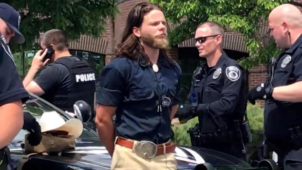 Thomas Rousseau, alleged founder and leader of white supremacist group Patriot Front, is held by police officers in Coeur d'Alene, Idaho, June 11, 2022, in this still image obtained from a social media video. 