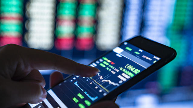 Close-up of hands of businesswoman analyzing stock market charts and key performance indicators 