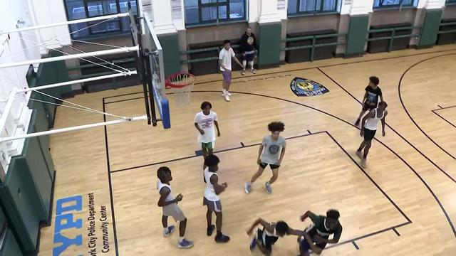 Children and teenagers play basketball at a New York City Police Department Community Center. 