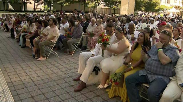 Hundreds of couples sit on folding chairs at the Lincoln Center plaza. 