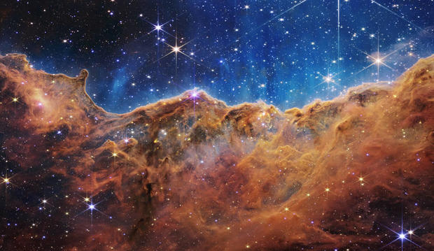 An image taken by the James Webb Space Telescope shows baby stars in the Carina Nebula, where ultraviolet radiation and stellar winds shape colossal walls of dust and gas. 