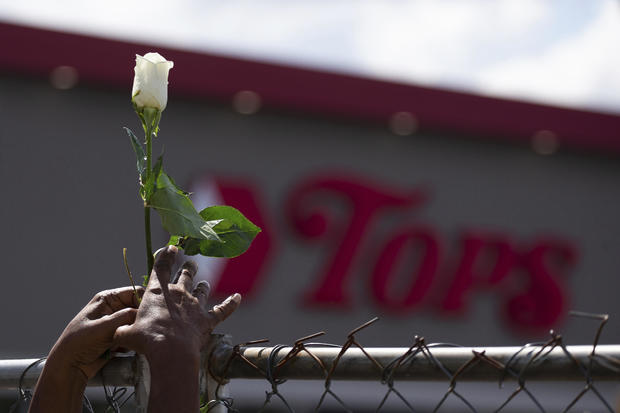 Cariol Horne, 54, places a rose on the fence outside the Tops Friendly Market on July 14, 2022, in Buffalo, New York. 