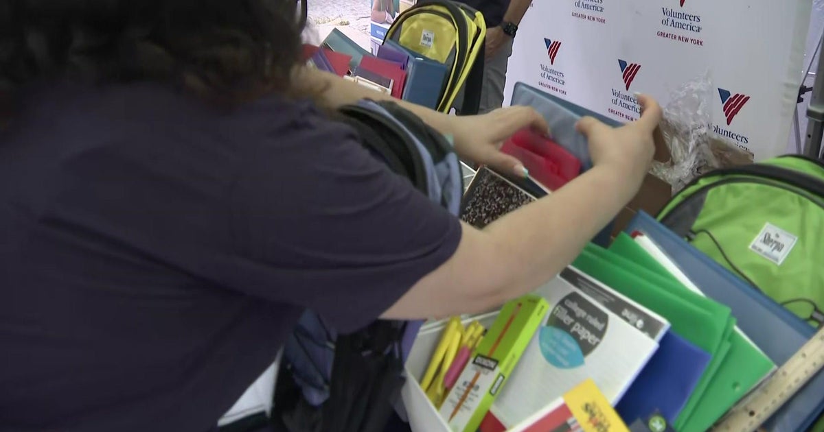 Volunteers help fill backpacks with school supplies for children in New