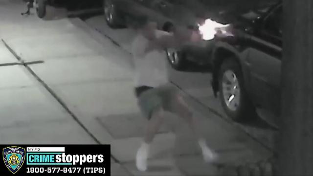 Surveillance video shows a man on a sidewalk firing a gun. 