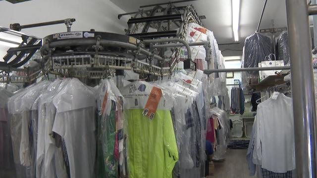 Racks of clothes at a dry cleaners. 