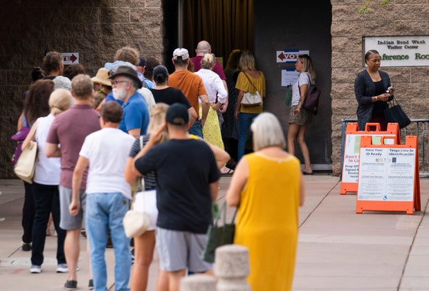 Voters wait in line to cast their ballots during the primary election in Scottsdale, Arizona 