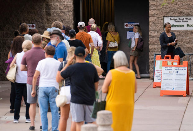 Voters wait in line to cast their ballots during the primary election in Scottsdale, Arizona 