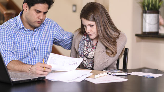 Young couple working out family finances together at home. 