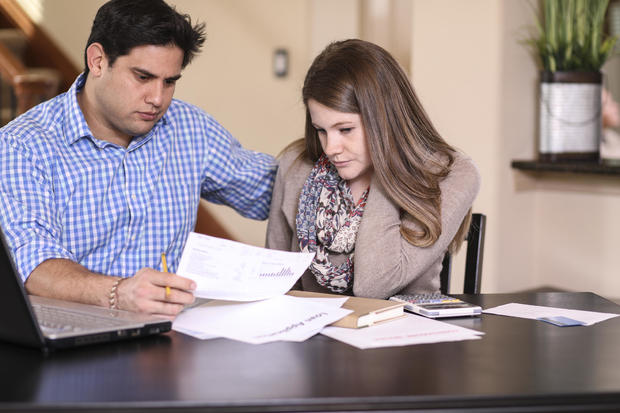 Young couple working out family finances together at home. 